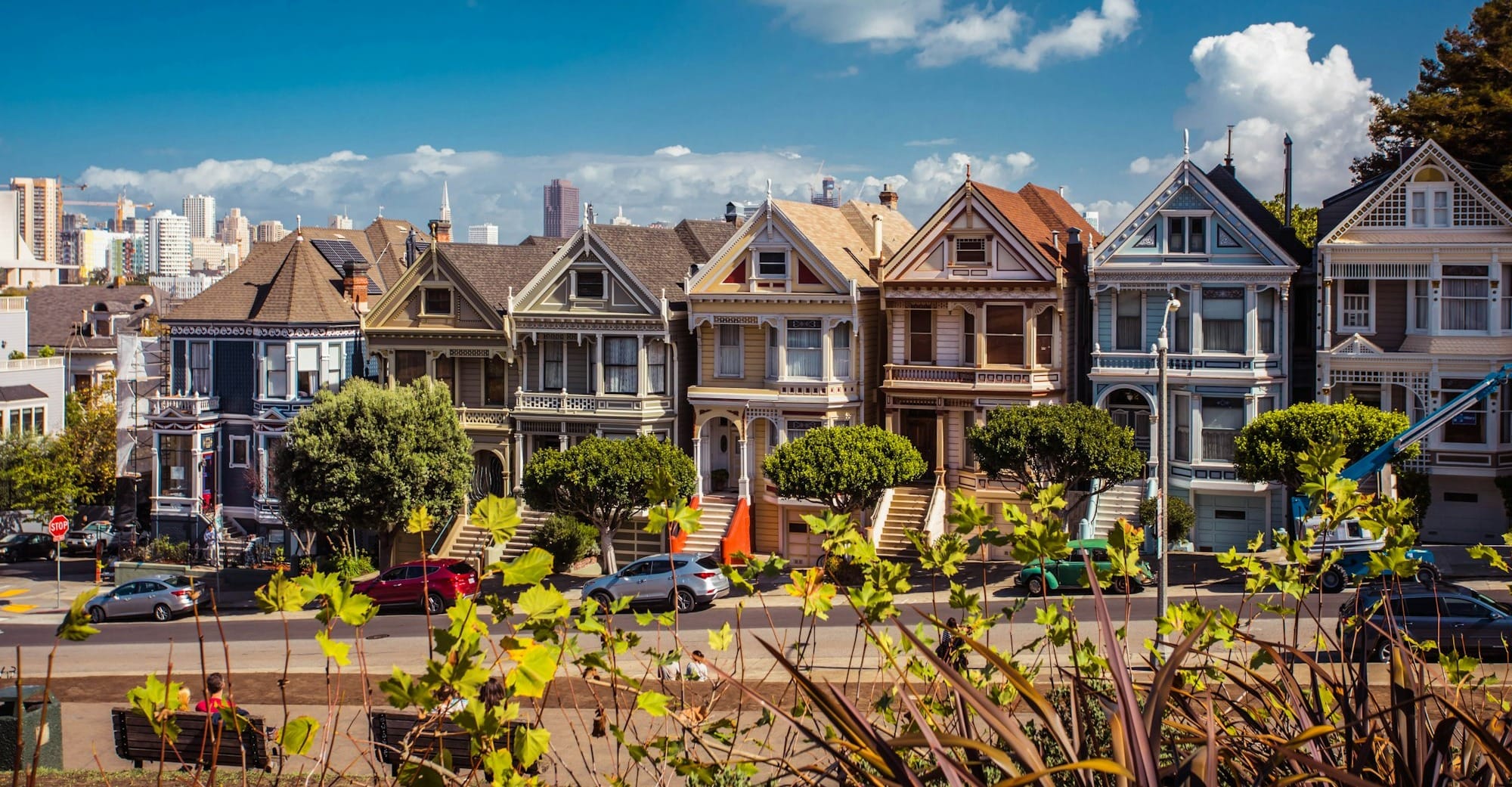 white and brown 2-storey houses with vehicles in front during daytime