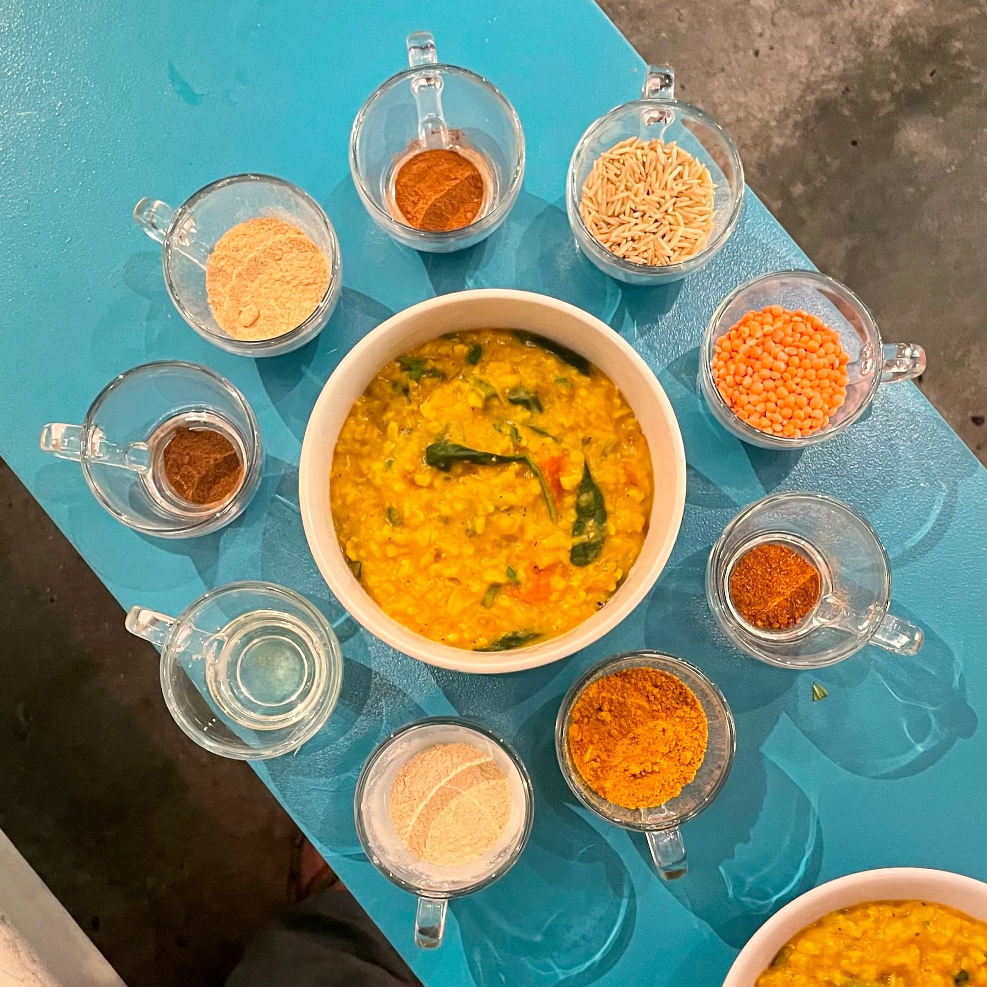 Photo of Ayurvedic preparation of kitchari with ingredients in a satellite formation.