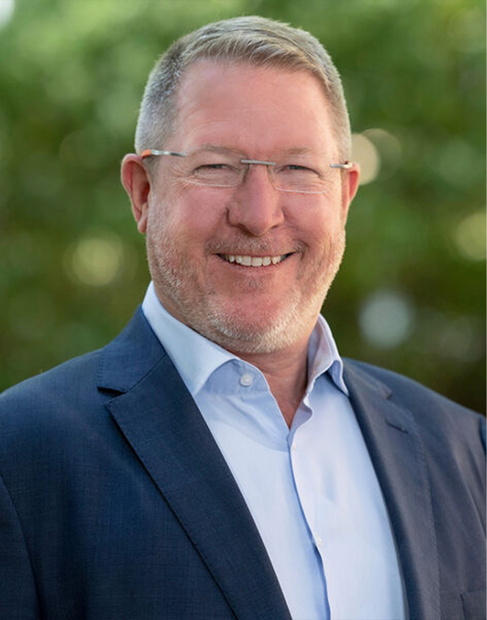 A person in a suit smiling

AI-generated content may be incorrect.