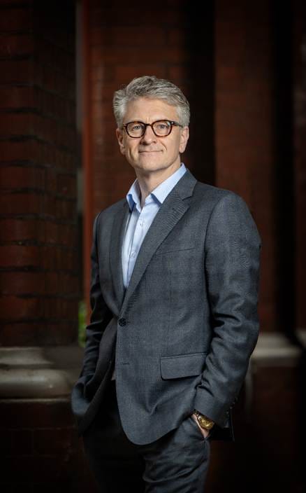 A person in a suit

AI-generated content may be incorrect.