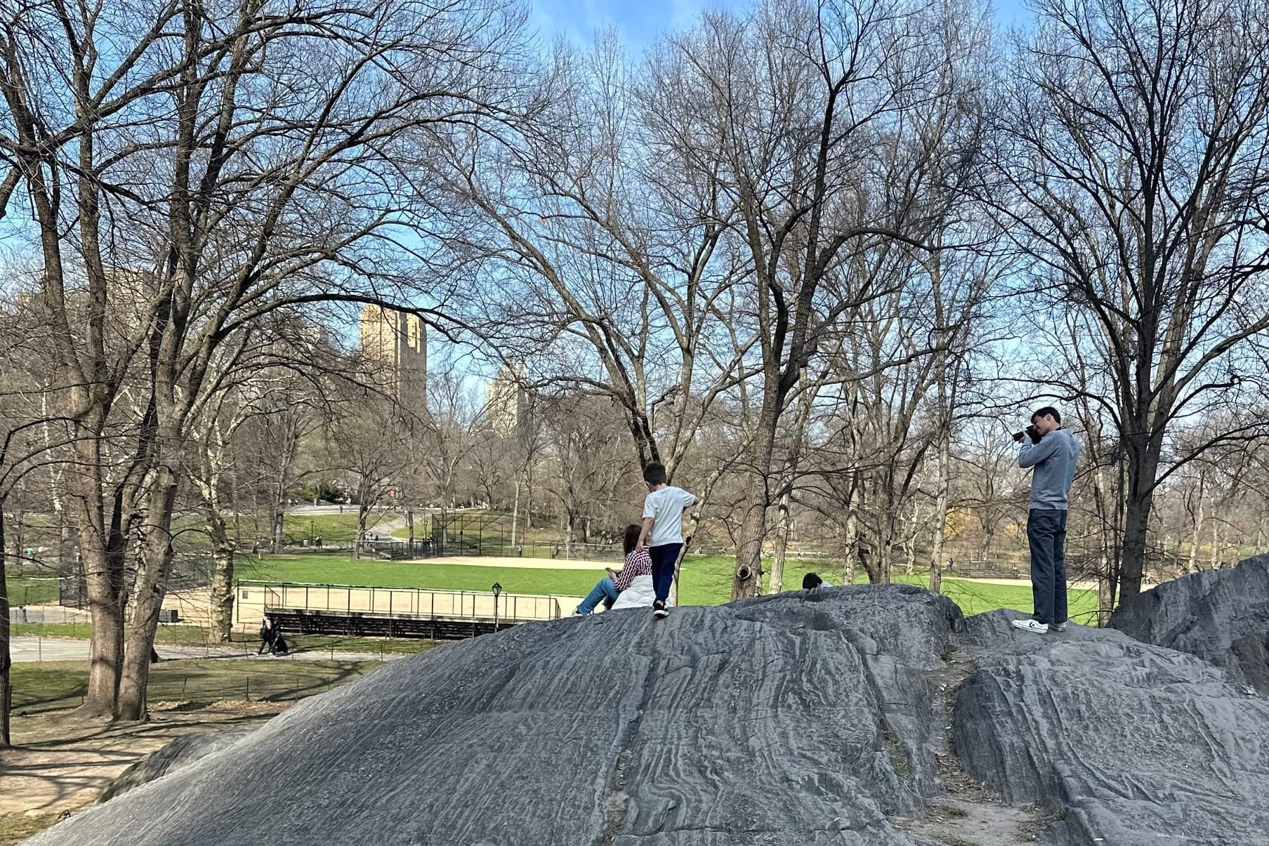 Kid running on the rocks in Central Park by Heckscher playground in New York City