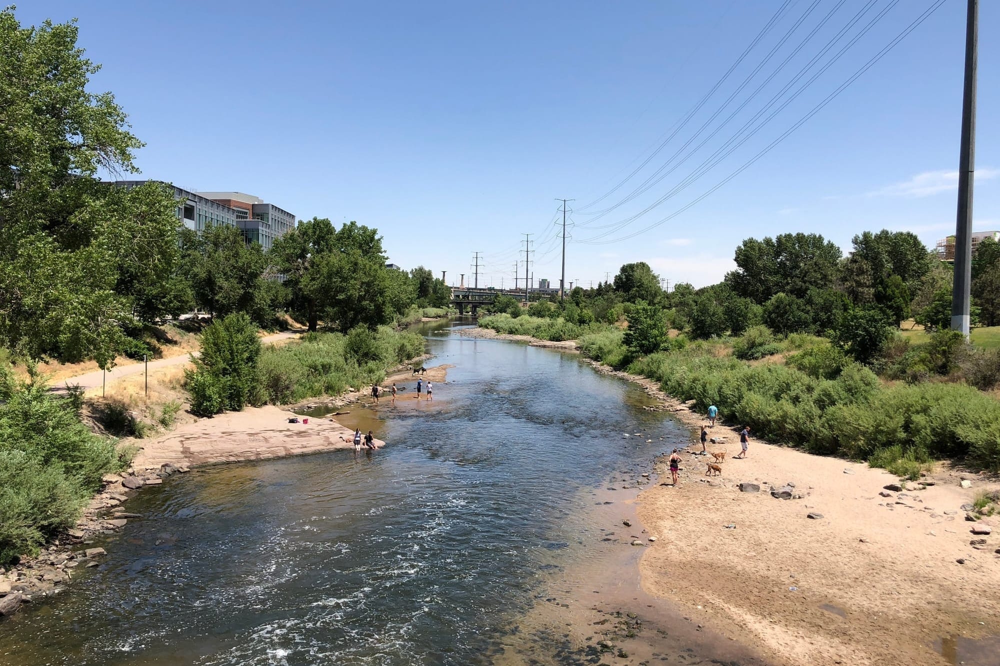 Crossing over the South Platte River in downtown Denver where families are playing by the water.