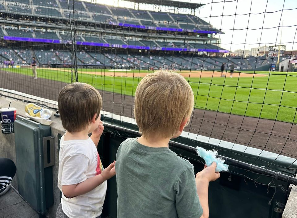 Young kids at a Colorado Rockies baseball game in Denver in summer