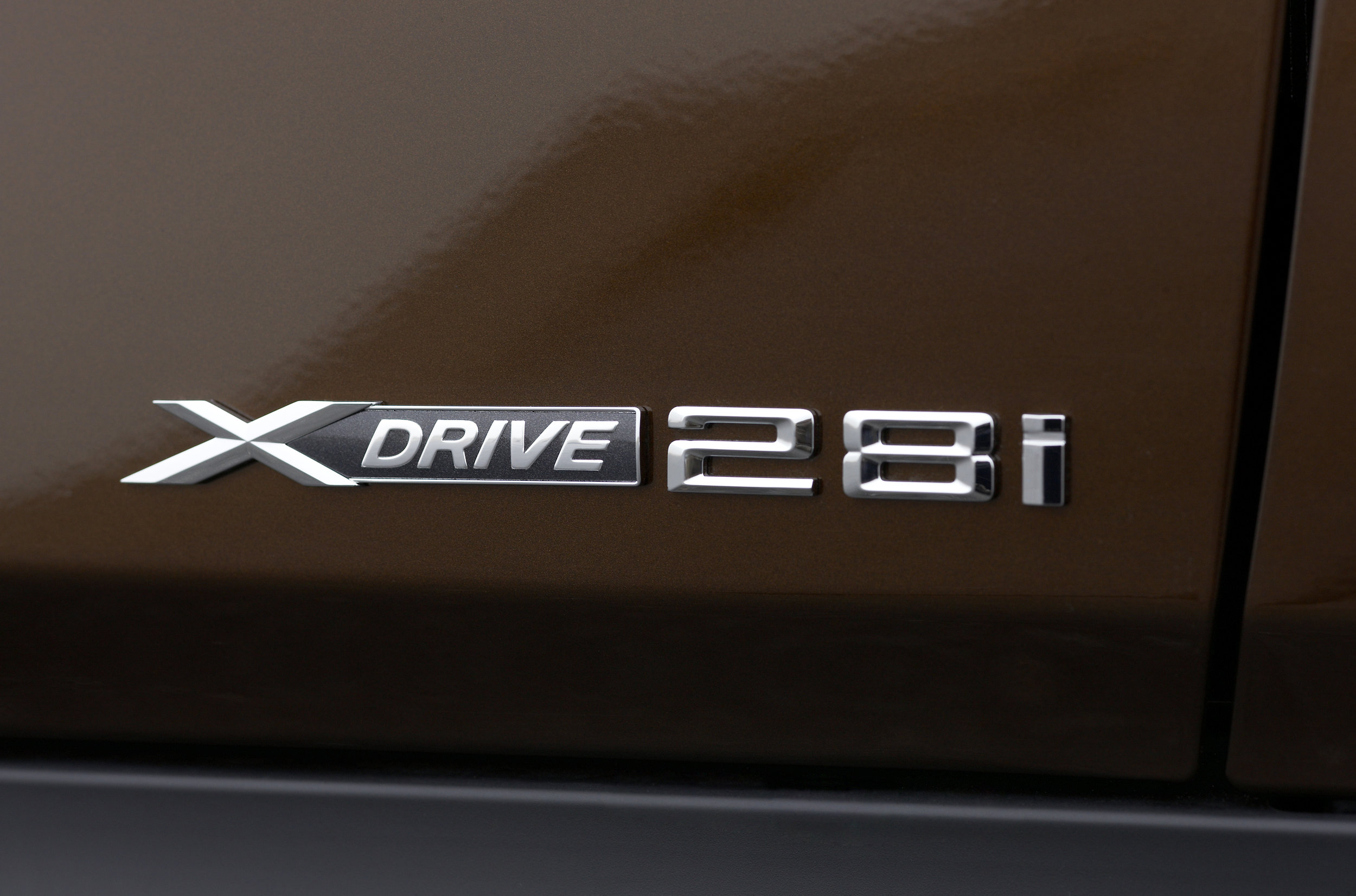  The badge above is from a BMW X1. Back in the 70s through the early 2000s, those two numbers would represent the engine displacement. However, the X1 does not have a 2.8-liter motor. It has a 2-liter motor. So what is this badge about? It's  an homage to the days when base BMW motors were 2.8 liters . Somehow BMW thought that this number would matter to longtime brand loyalists. I don't think it does. 