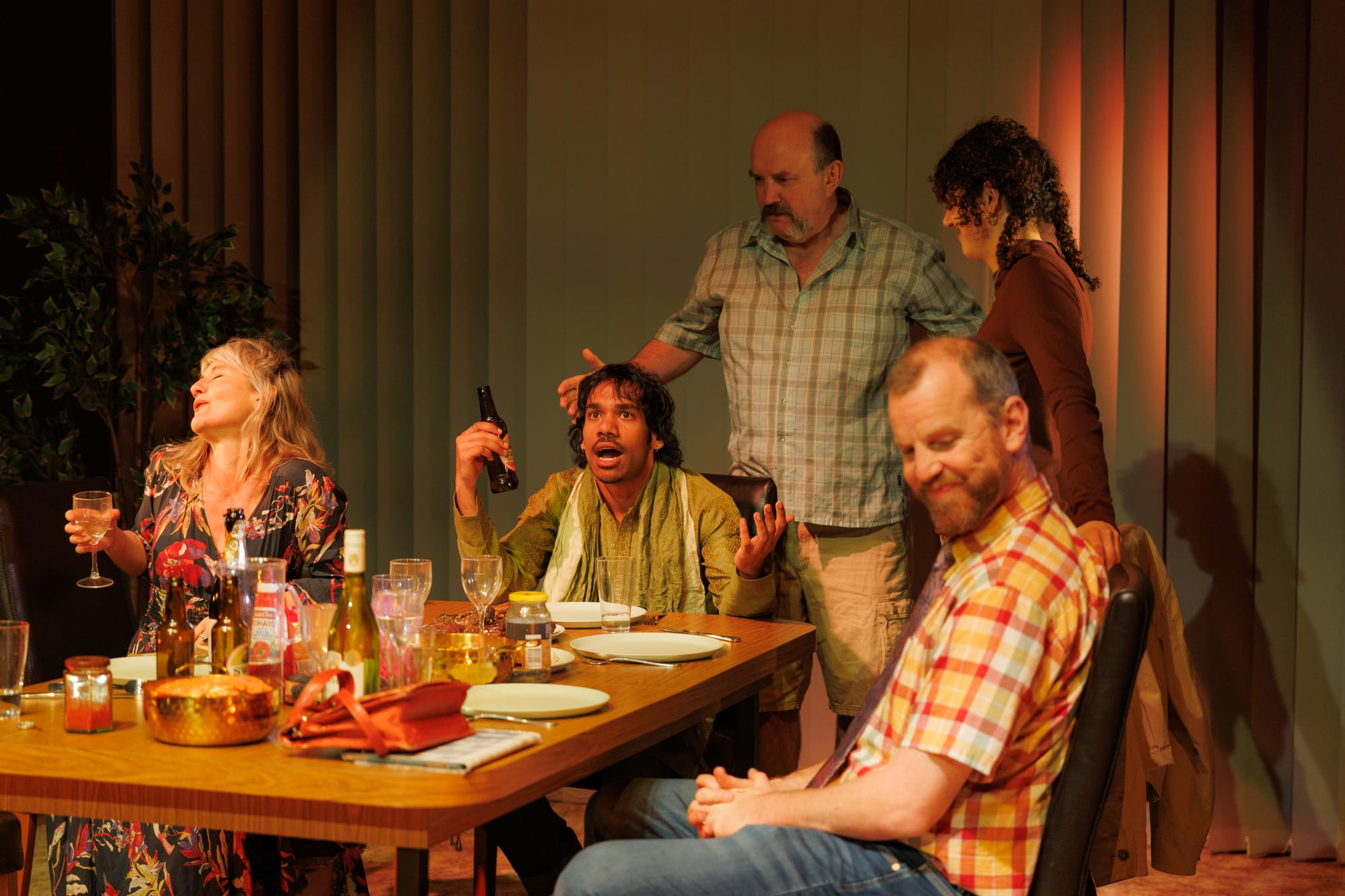The Cut Chilli cast gathered around a crowded family dinner table, with Jamie gesturing animatedly at its centre.