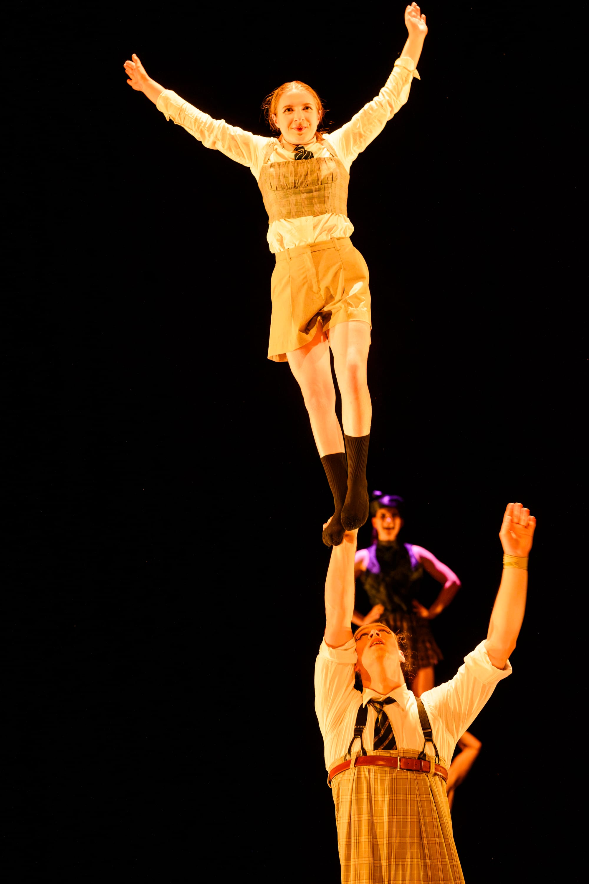 Eliza Denlay balances high above James Wilson during an acrobatic ensemble sequence.