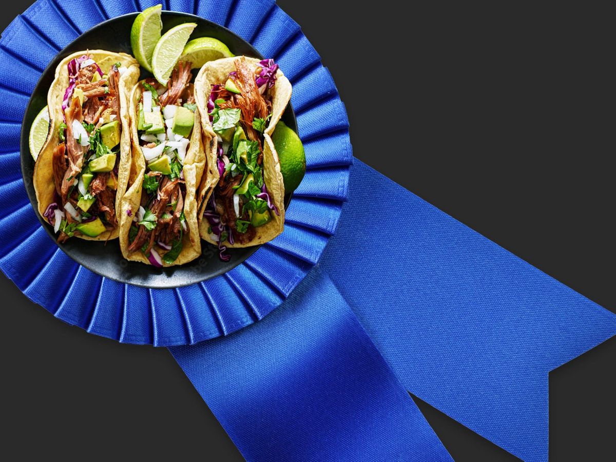 Three tacos on a blue ribbon over a black background.