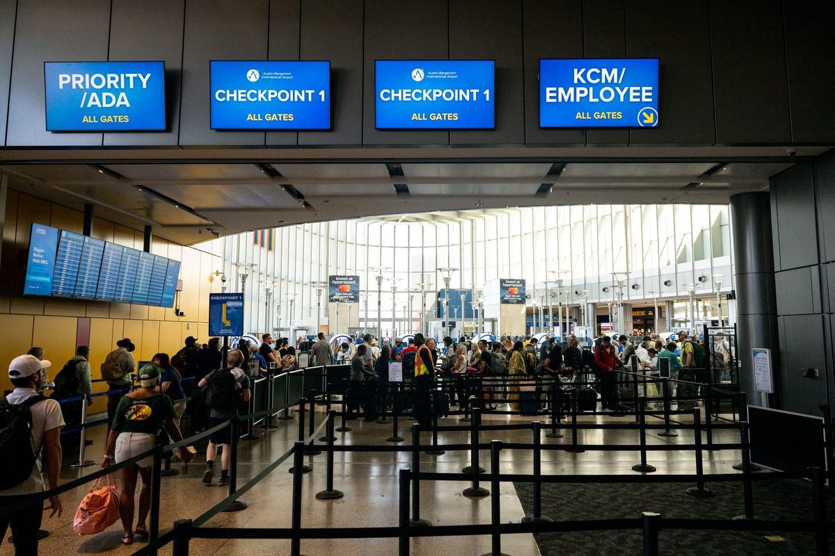 Travelers walk through a TSA security checkpoint following a government shutdown at the Austin-Bergstrom International Airpor