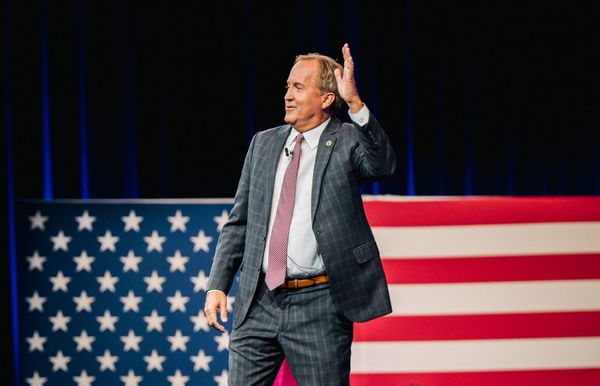 Paxton waving in front of an American flag