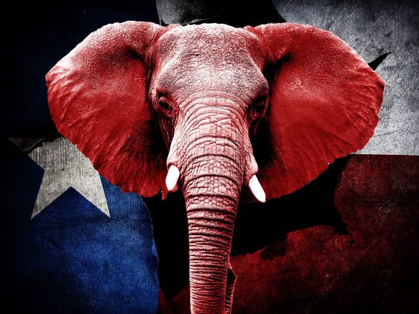 a red elephant walking in front of a Texas flag