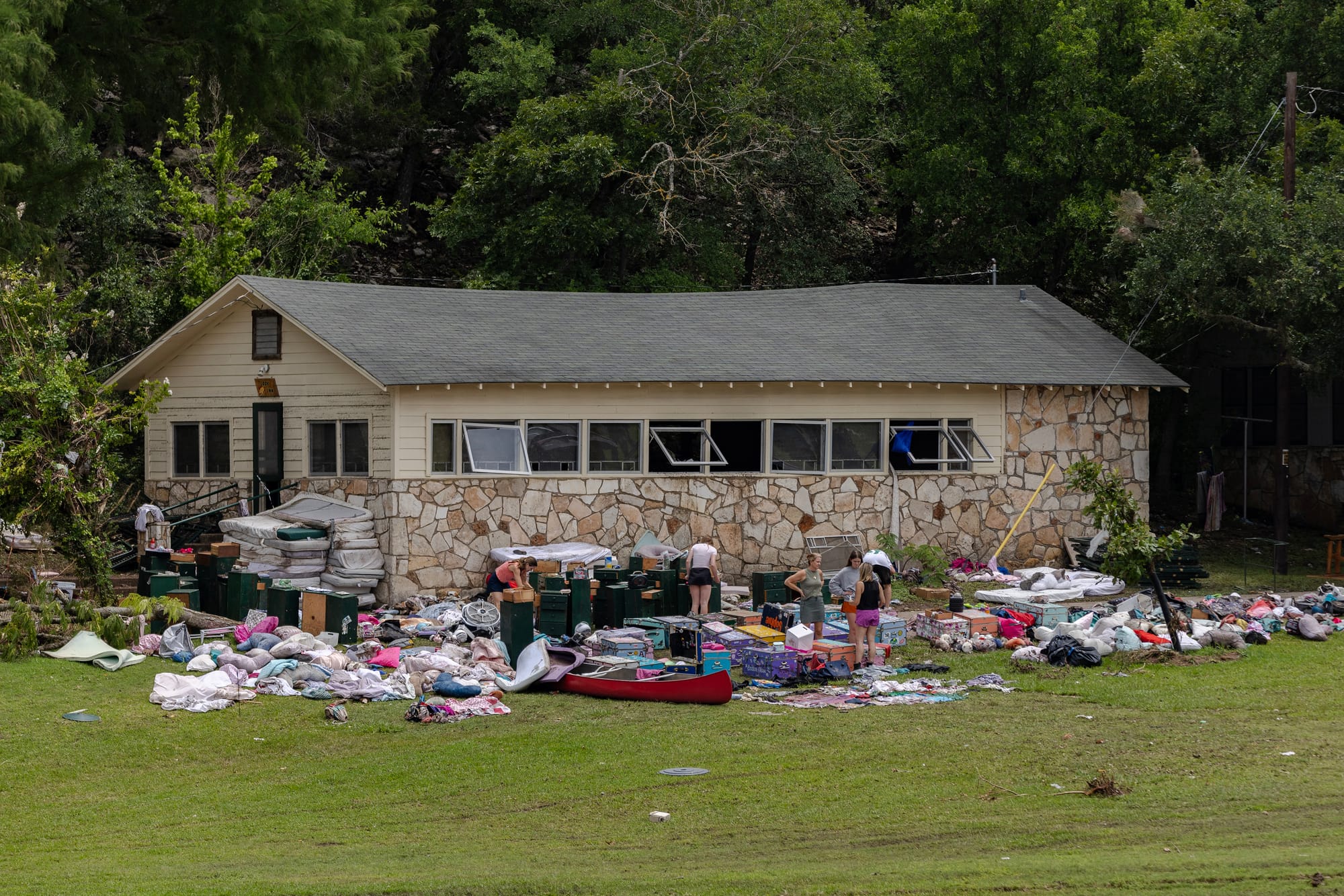 People look through items left in the bunks at Camp Mystic not swept away in the flash flooding on July 7, 2025 in Hunt, Texas. (Photo by Jim Vondruska/Getty Images).