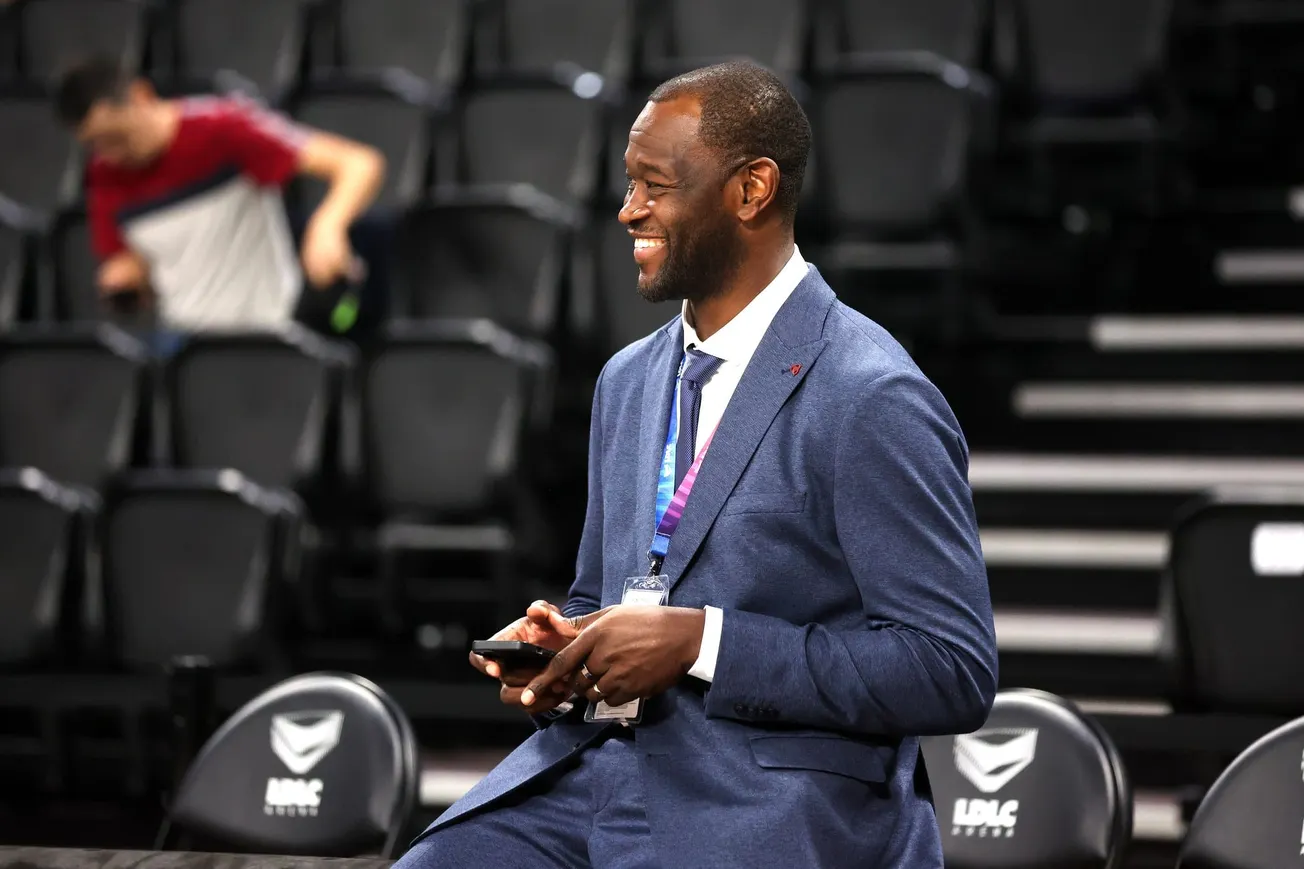 Charles Kahudi, de l'ASVEL, souriant en costume au bord du terrain lors du match d'Euroleague entre l'ASVEL et Valence à la LDLC Arena de Lyon, le 2 octobre 2026