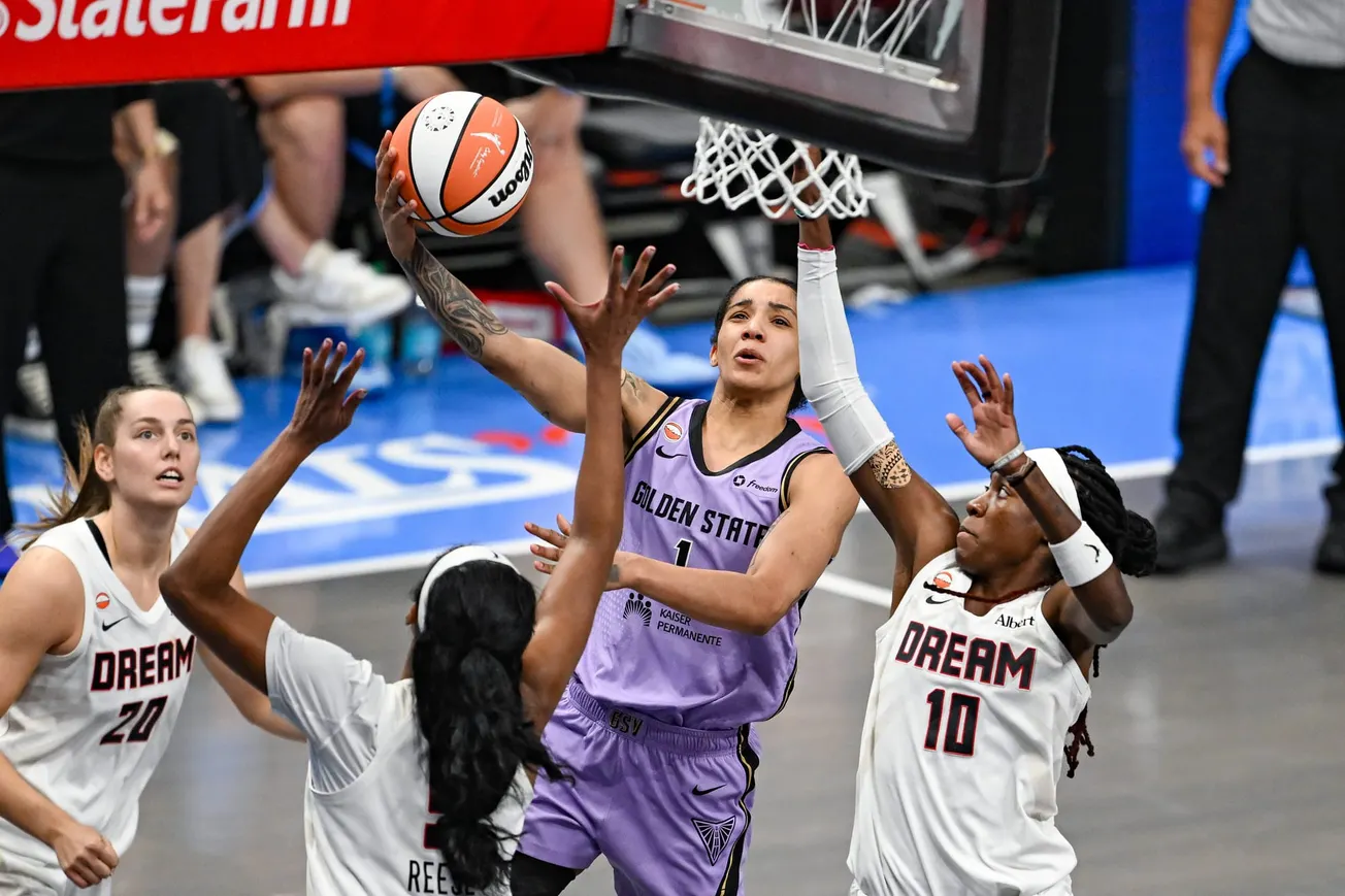 Une joueuse des Golden State Valkyries au layup face à trois défenseures de l'Atlanta Dream, dont Angel Reese, lors d'un match de WNBA
