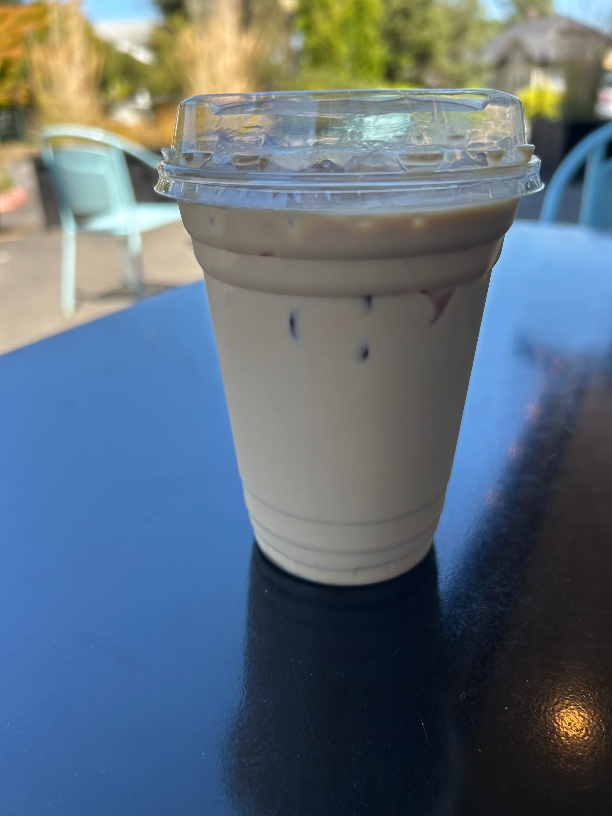 iced coffee in a plastic cup on a shiny black table