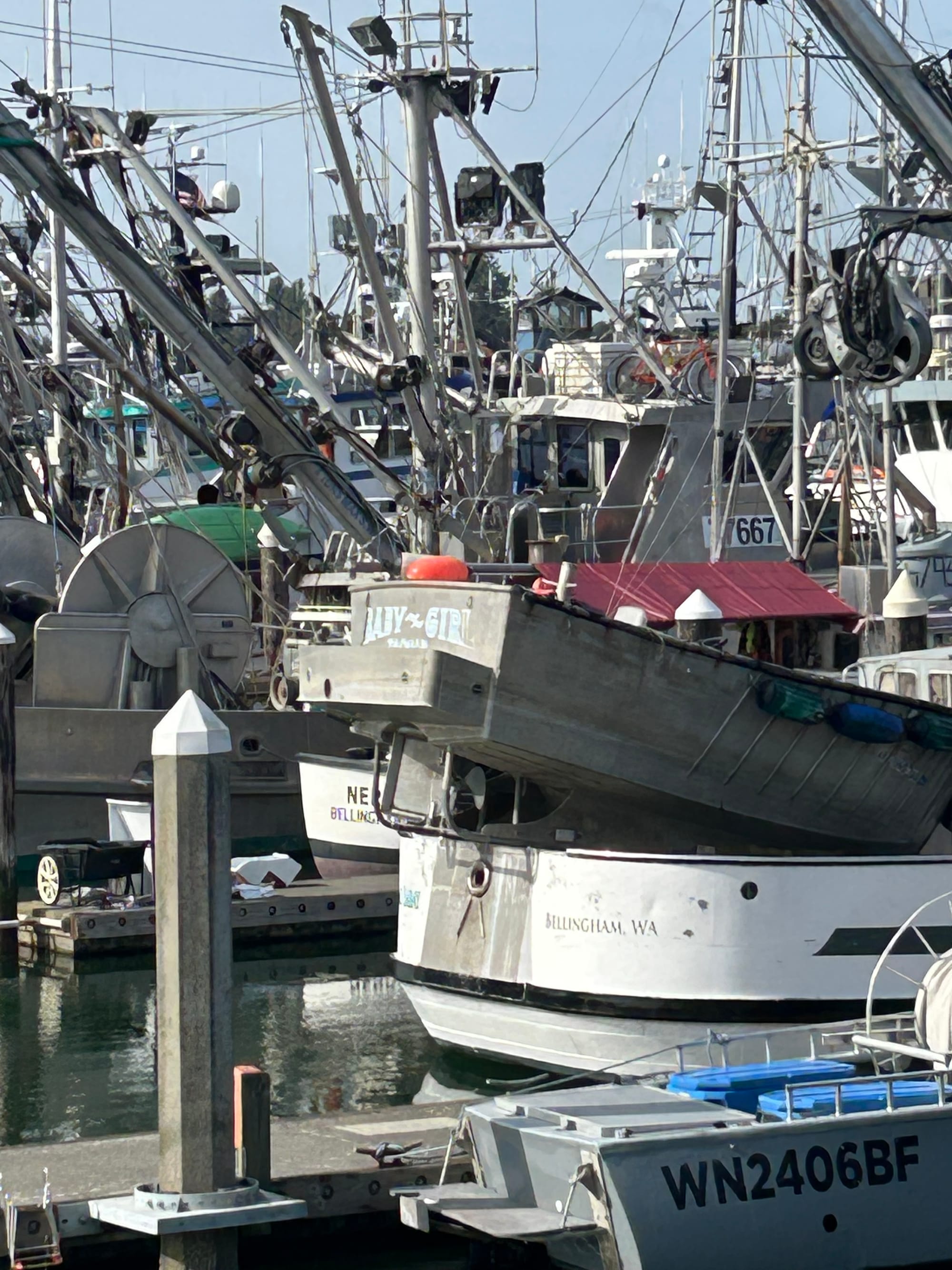 shot of fishing boats in a harbor. a dinghy with the name baby girl in the center of the shot.