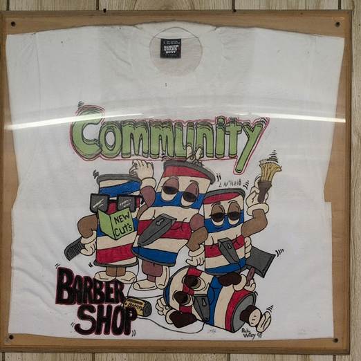 A second piece of artwork hanging inside Community Barber Shop turns barber tools and barber poles into a playful “Community” design, reflecting the shop’s identity and atmosphere.