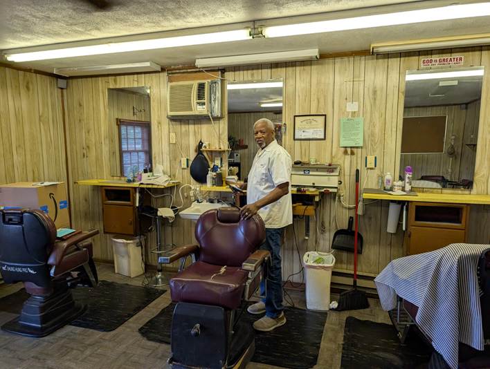 George “David” Thompson stands behind his barber chair inside Community Barber Shop at 2612B Cove Road NW, where he cut hair for 46 years. Thompson began barbering in 1965 and retired after 61 years behind the chair.