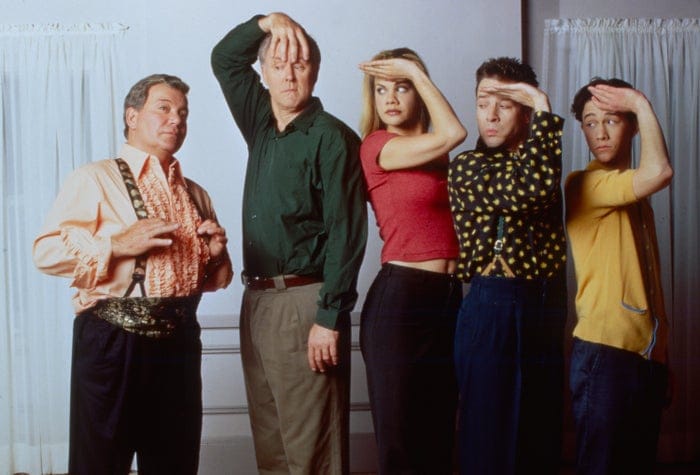 Five people in humorous poses, each with one hand on their forehead. They&amp;#x27;re standing in a line, wearing varied casual outfits