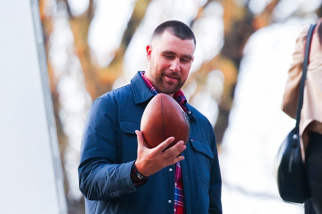 Travis Kelce holding a football during a photoshoot in Central Park.