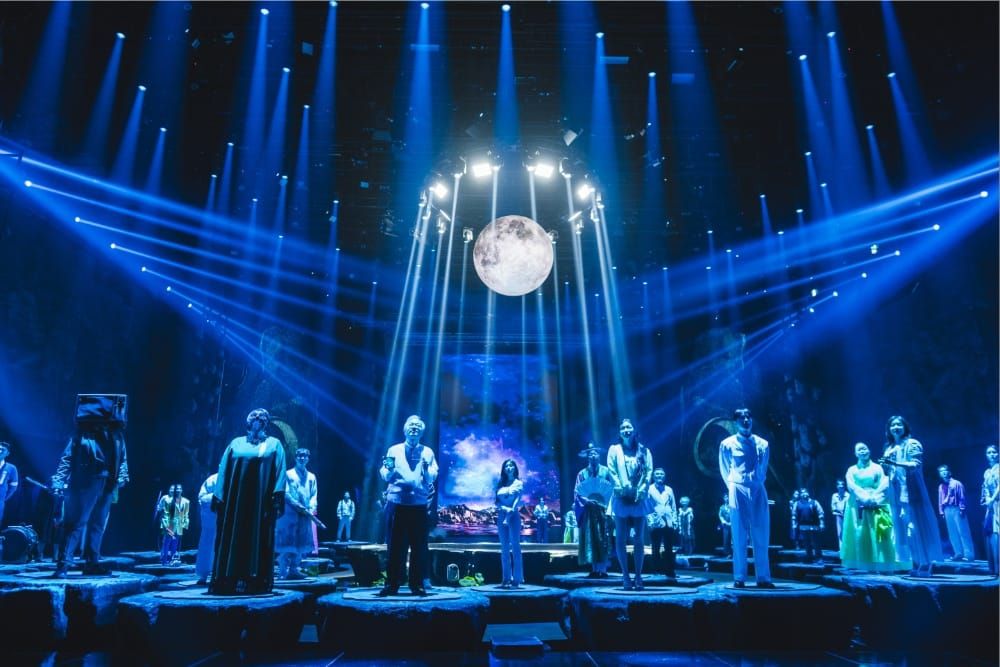A still from Battle of Fates showing contestants in a supernatural-themed challenge—tarot cards, occult symbols, atmospheric lighting—that visually communicates the show's genre without re...