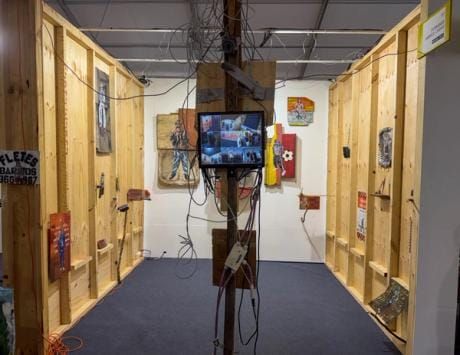 Installation view from Chaco art fair showing booth displays with accessible price points, visitors engaging with political artwork, or specific Latin American works with visible pricing