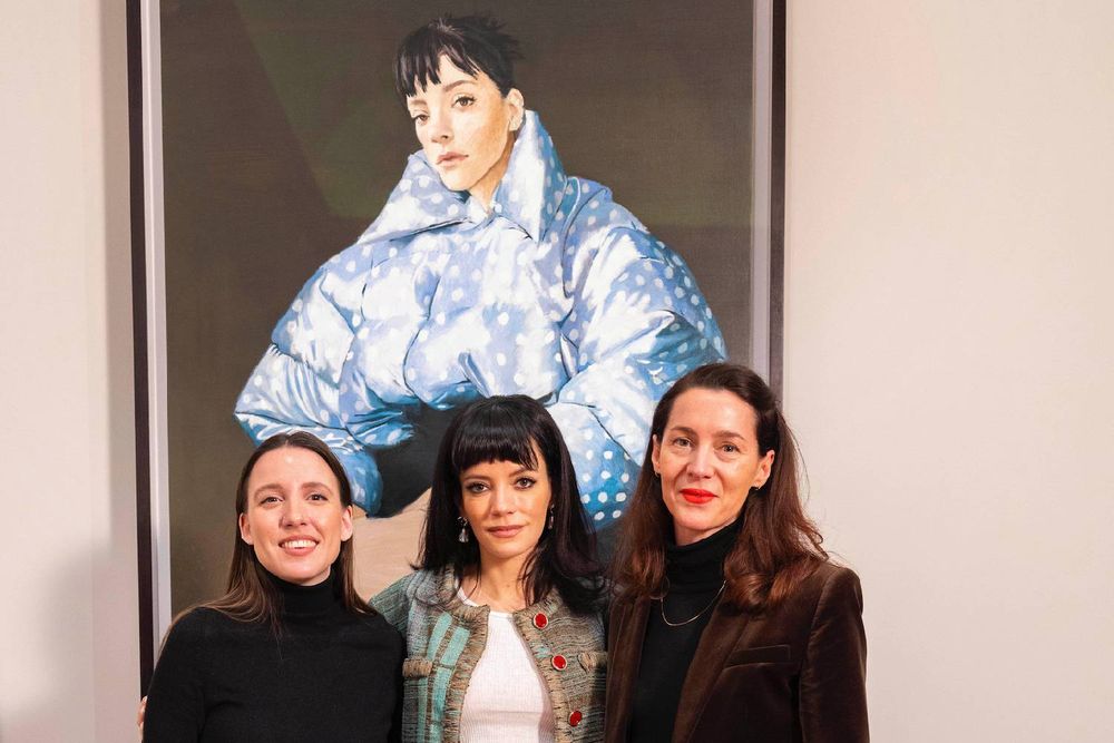 Nieves González's portrait of Lily Allen in the oversized blue-and-white polka-dotted puffer jacket against a dark background — the painting itself, not installation shots
