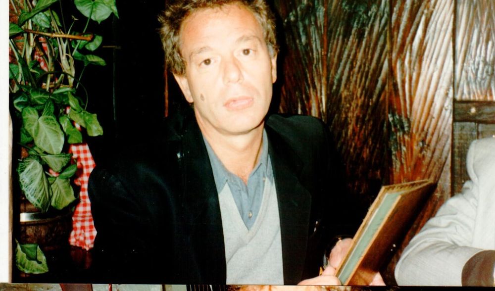 A vintage photograph of Peter Thompson at a theatrical opening night or press event, ideally from the 1980s era of mega-musical launches, showing him in his element orchestrating publicity...