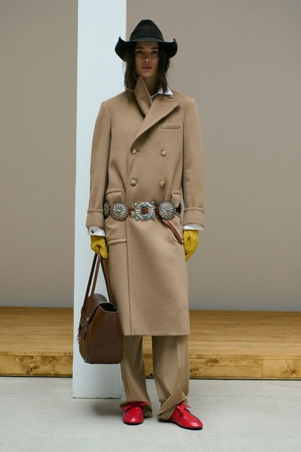 A runway image from Polo Ralph Lauren Fall 2026 showing the navy peacoat, cable-knit sweater, and flannel trousers look — clean, classic, and timeless. Alternatively, a wide shot of the co...