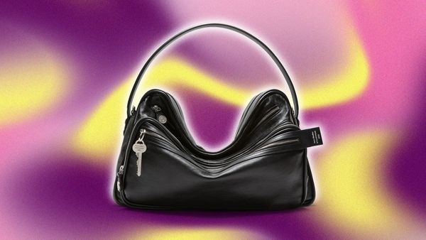 A clean, editorial-style shot of the Acne Studios Camero bag — ideally carried by someone in a minimal, well-tailored outfit on a city street. The image should emphasize the bag's structur...