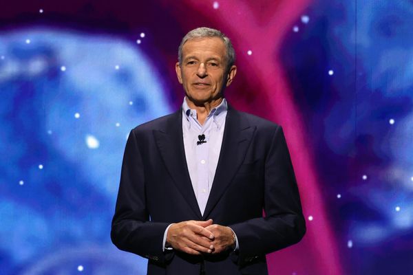 Bob Iger at a Disney shareholder meeting or corporate event, ideally with Disney branding visible in the background — conveys the scale and corporate power of his tenure