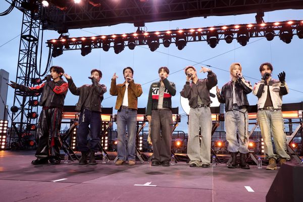 BTS performing at Pier 17 in New York, ideally showing the intimate venue setup contrasted with the scale and production values the group is known for, or a wide shot capturing the waterfr...