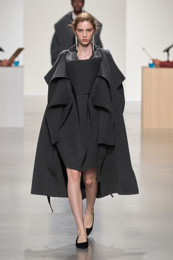 A look from CFCL Fall 2026 showing the seamless construction and fluid draping that demonstrates the technical innovation—ideally a full-length garment that reveals the three-dimensional s...