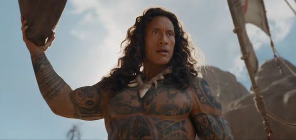 A still from the Moana live-action trailer showing Dwayne Johnson in costume as Maui with the controversial curly wig, ideally a close-up that shows the texture and styling that sparked th...