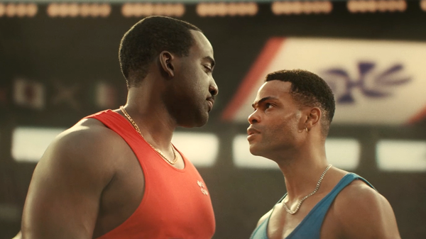 A production still from Hate the Player showing Shamier Anderson as Ben Johnson—ideally in athletic gear, mid-sprint or in a moment of dramatic tension. The image should capture both the p...