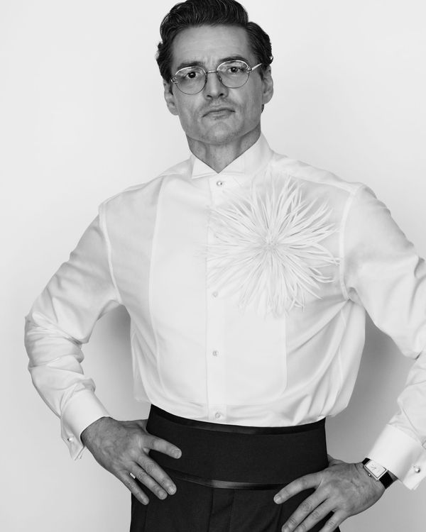 Pedro Pascal on the Oscars red carpet in the custom Chanel jacketless tuxedo — white shirt, black trousers, bow tie, full-length shot showing the silhouette and tailoring