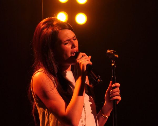 Sienna Spiro performing at the Troubadour — ideally a moment capturing her mid-performance with dramatic stage lighting, showing both the intimacy of the venue and the command of her prese...