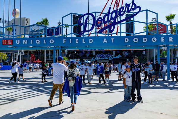Exterior shot of Dodger Stadium with Uniqlo branding visible, or a wide-angle view of the stadium during a game showing the venue's iconic architecture and crowd
