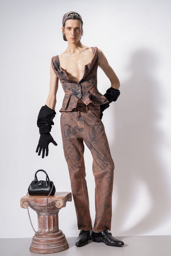 A runway look from Vivienne Westwood Fall 2026 featuring the tartan corset dress or bondage-strap detailing—something that visually captures the tension between punk heritage and commercia...