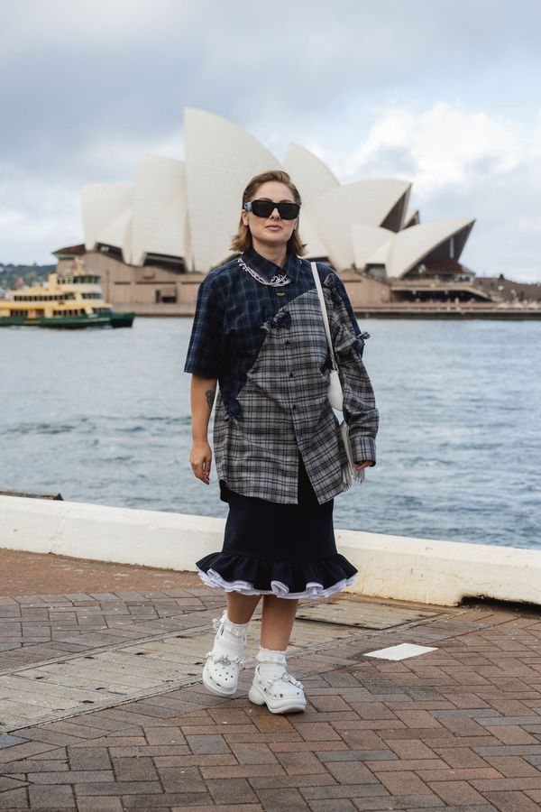 A full-length street style shot from Rachel Yabsley's Sydney Resort 2027 coverage showing the architectural layering and neutral palette described — ideally someone in an oversized blazer ...