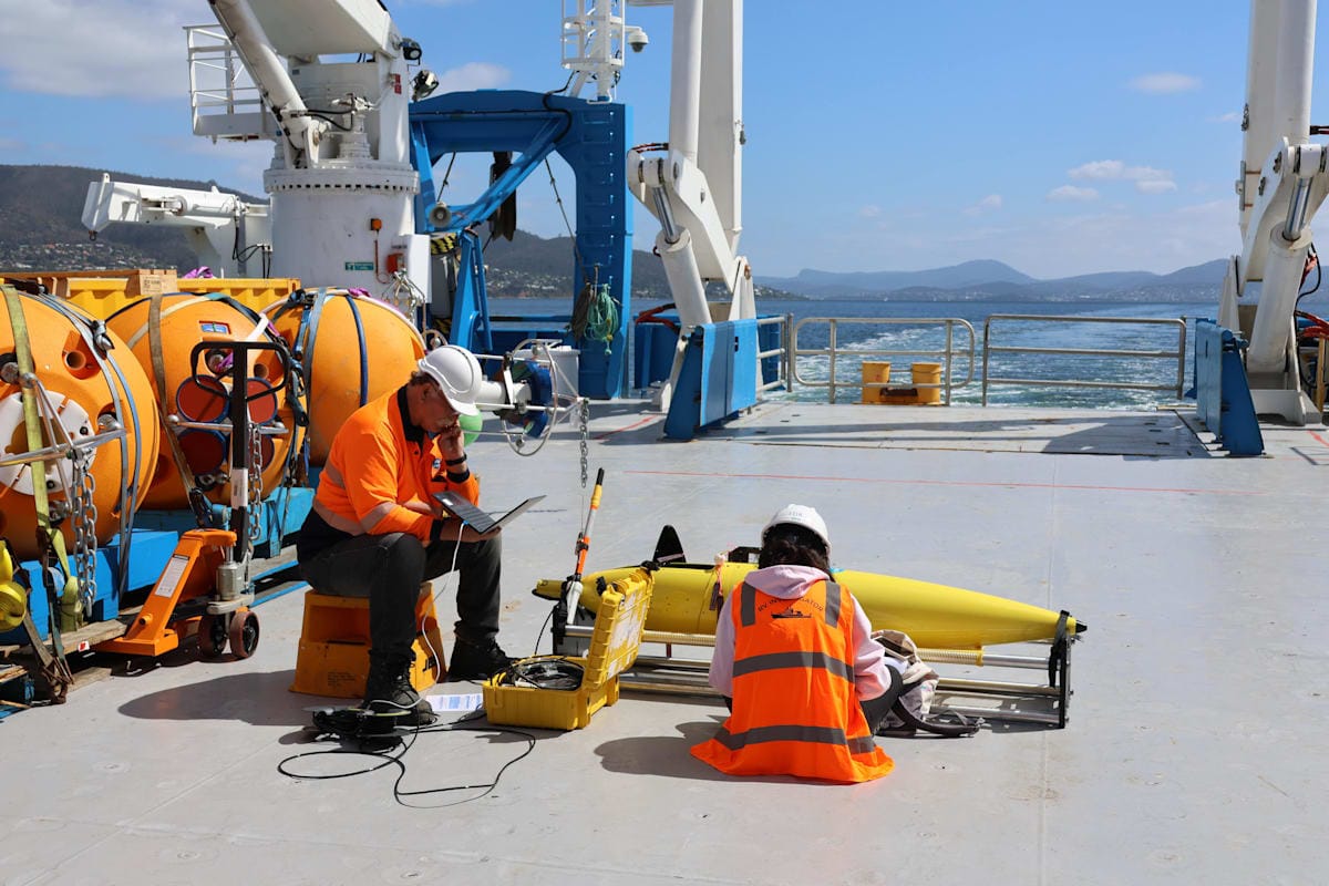 Two people working on a deep-sea gliders on the deck of the research vessel Investigator