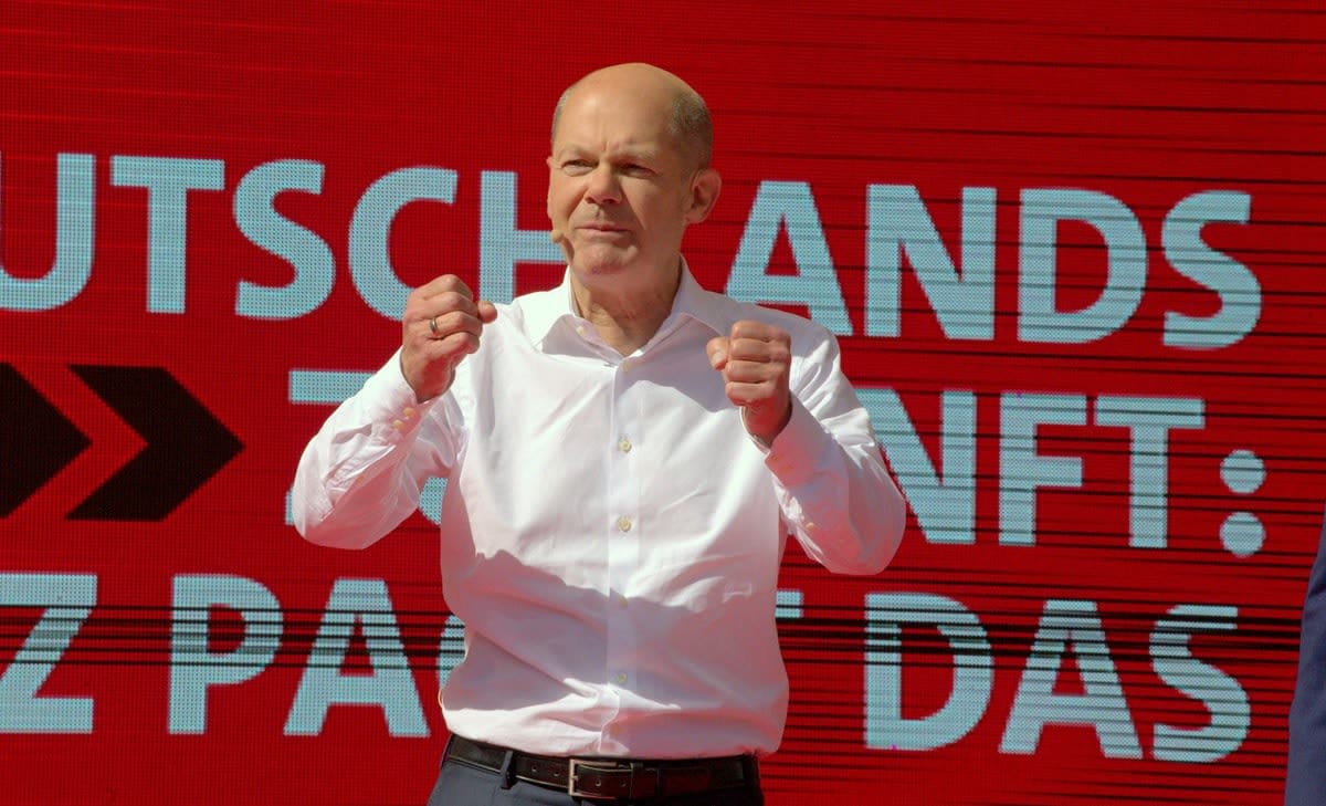 Olaf Scholz speaking in front of a sign at a campaign rally before becoming German chancellor