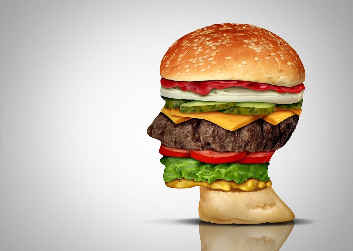 Binge-eating concept, with a burger in the shape of a human head