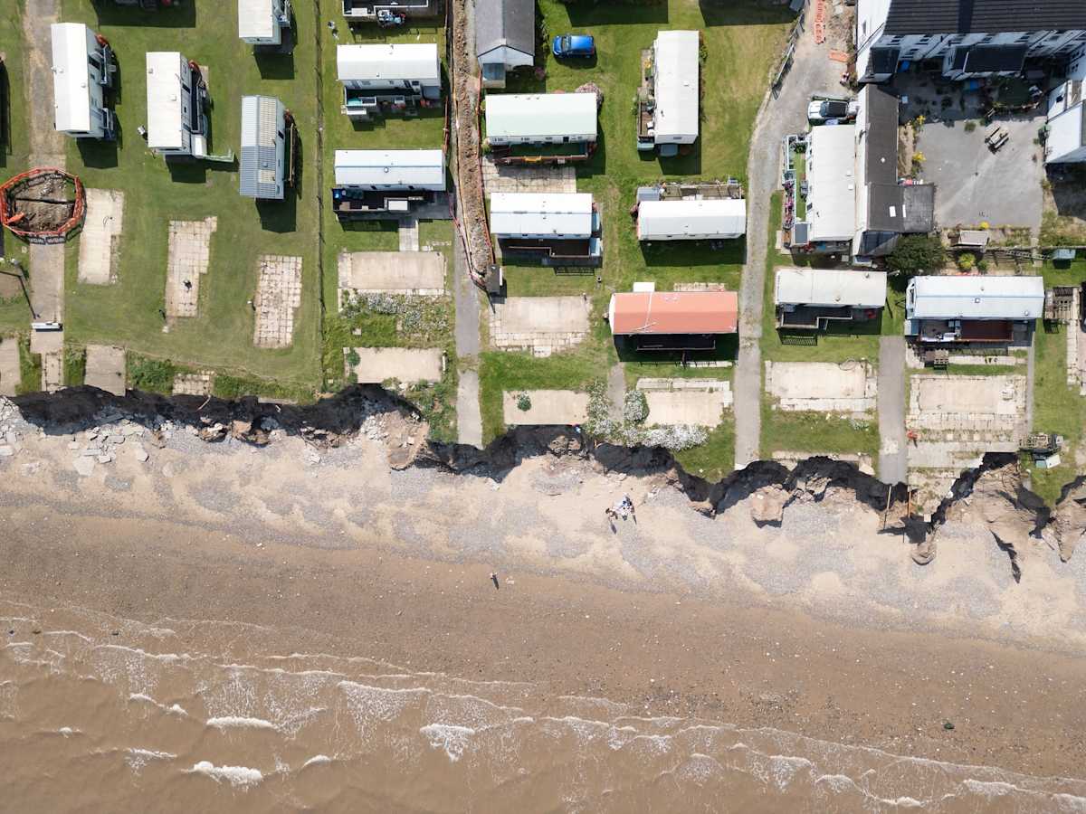 Houses on a coastline being threatened by beach erosion.