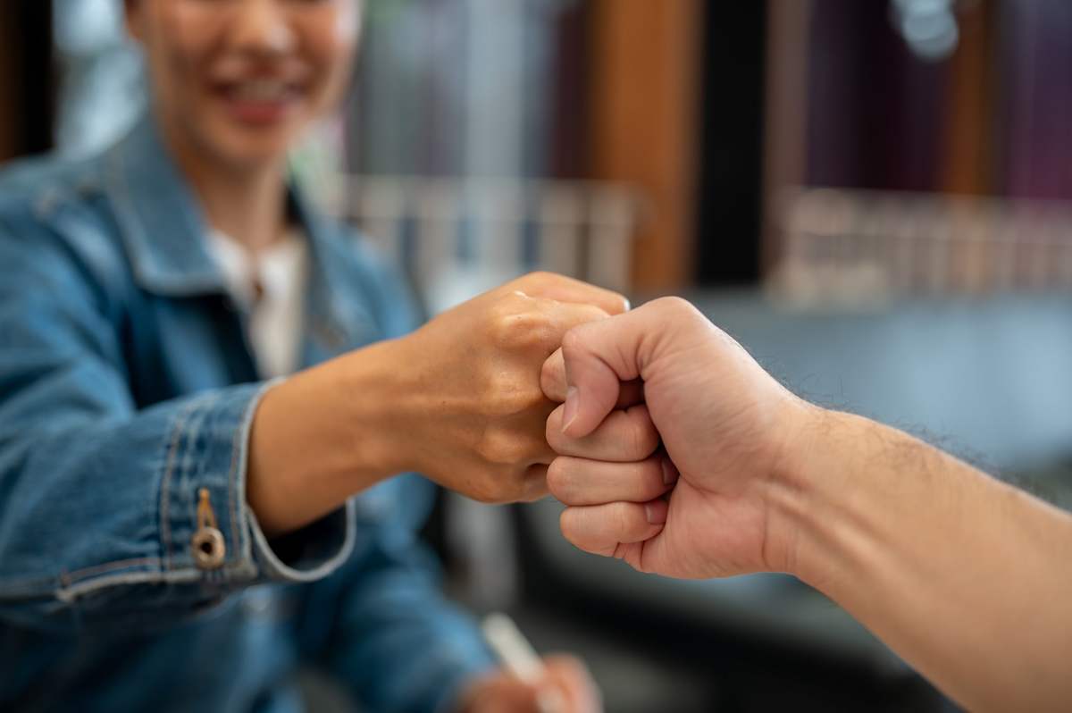 Close-up of two young people giving each other a fist bump