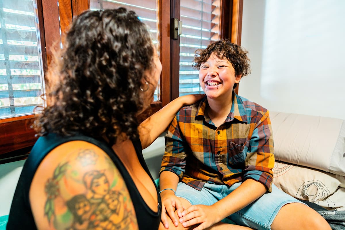 Transgender male talking with mother at home