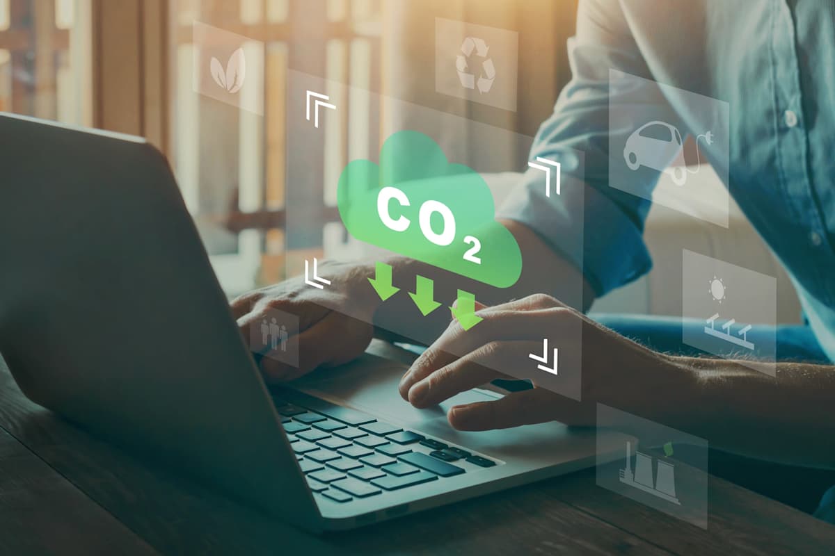 Man typing on a laptop with reducing CO2 emissions icon