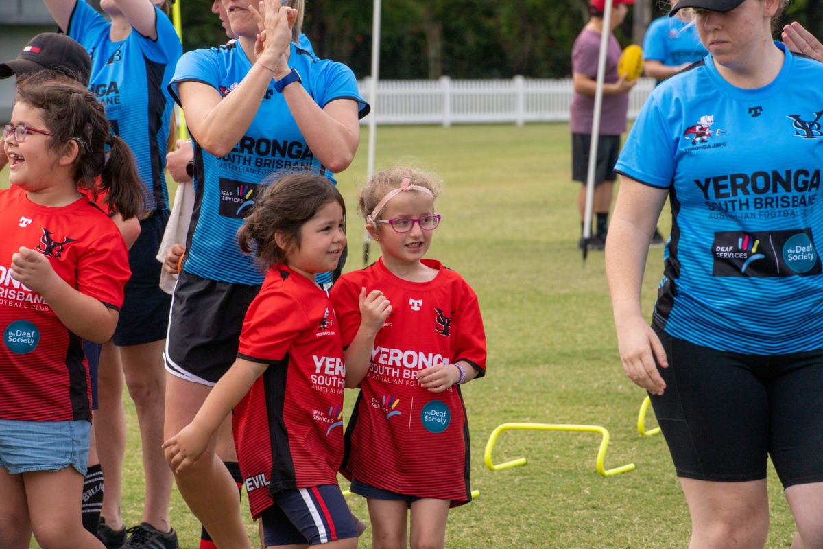 Two young girls and instructors at a football session 