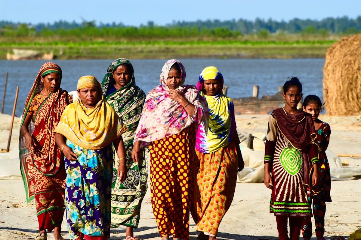 A group of woman Bangladesh walking together around a river bank. 