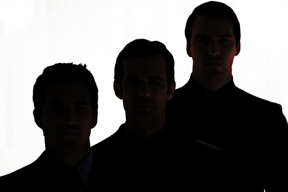 Upper-body silhouettes of three men, shortest to tallest