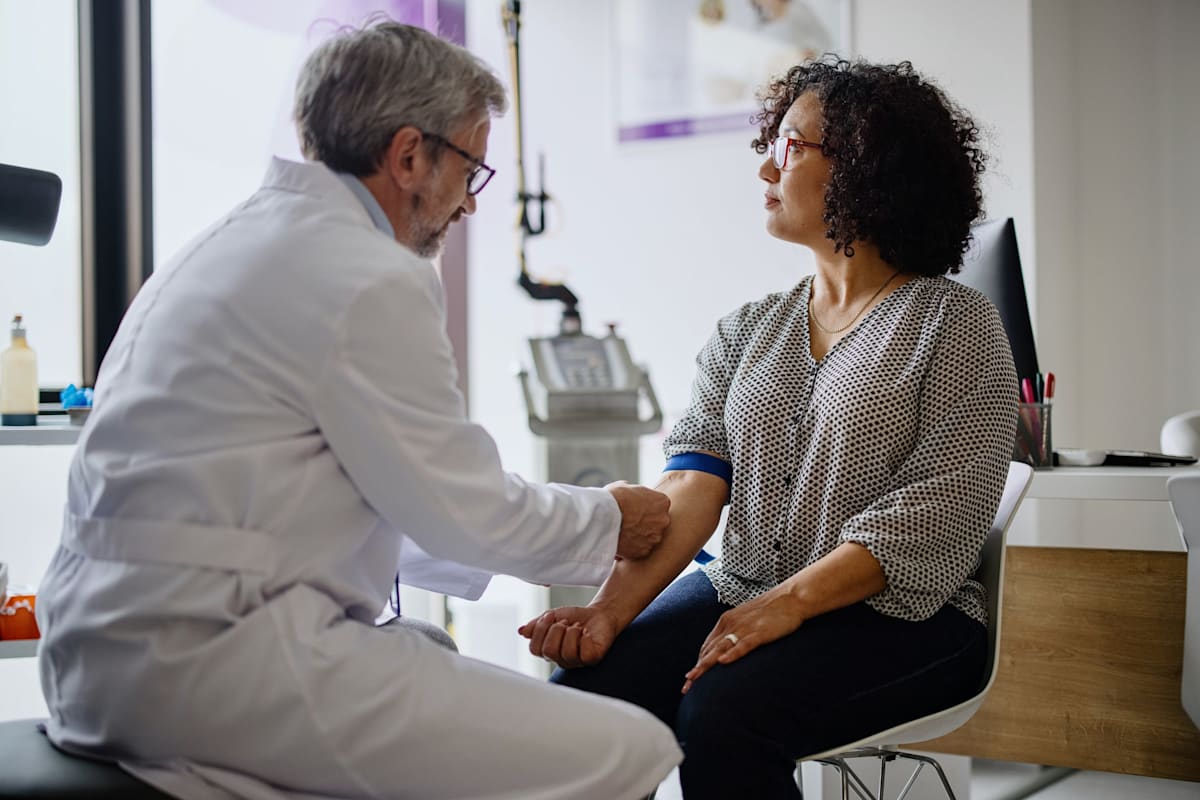 A doctor conducting a hormonal blood test on a woman to check for menopause